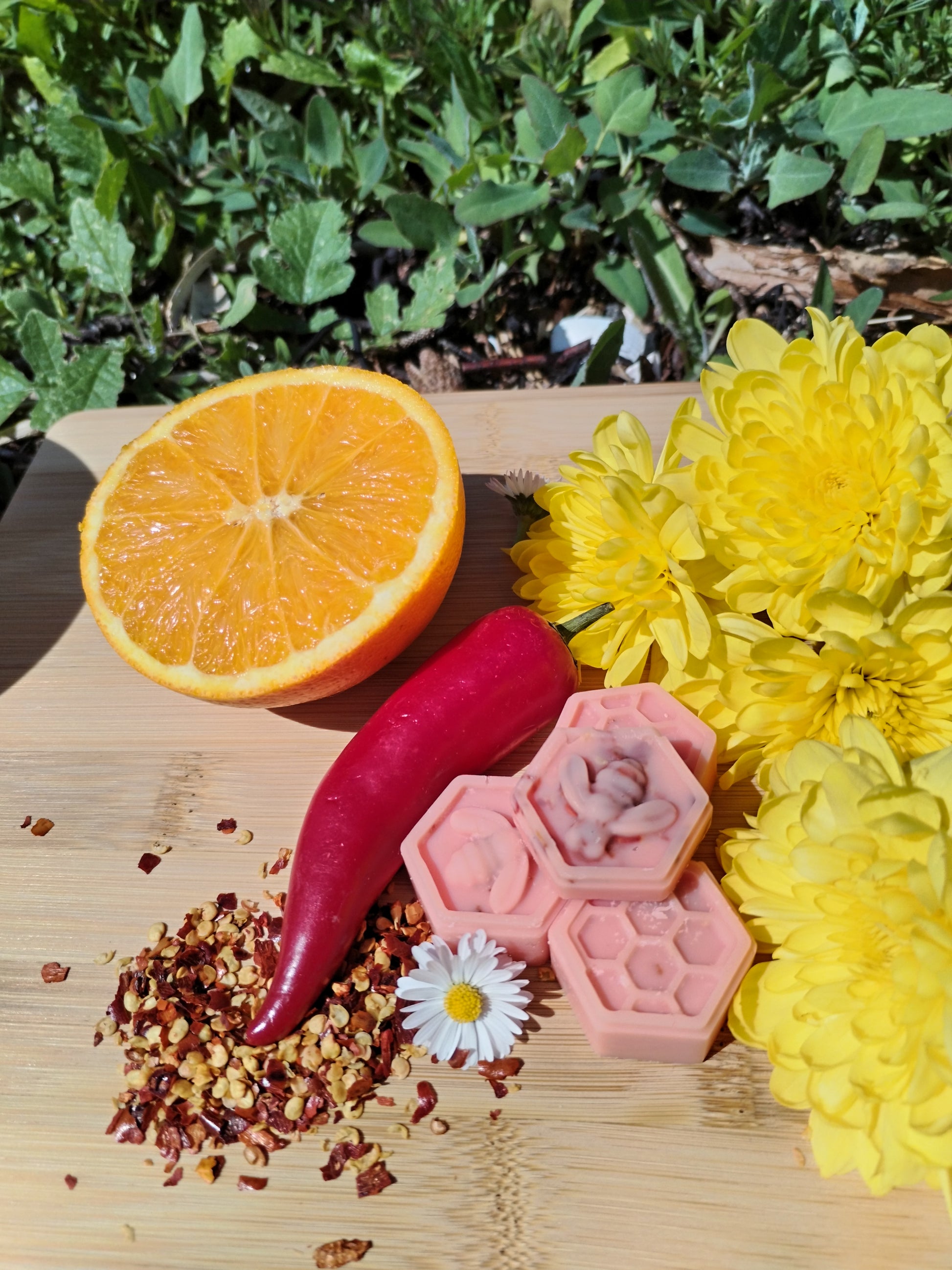 Handcrafted Honeycomb Wax Melts with Bee, Chilli Pepper, Orange, Daisy, and Yellow Flowers on Bamboo Chopping Board - A Symbol of Natural Delight and Mystical Ambiance