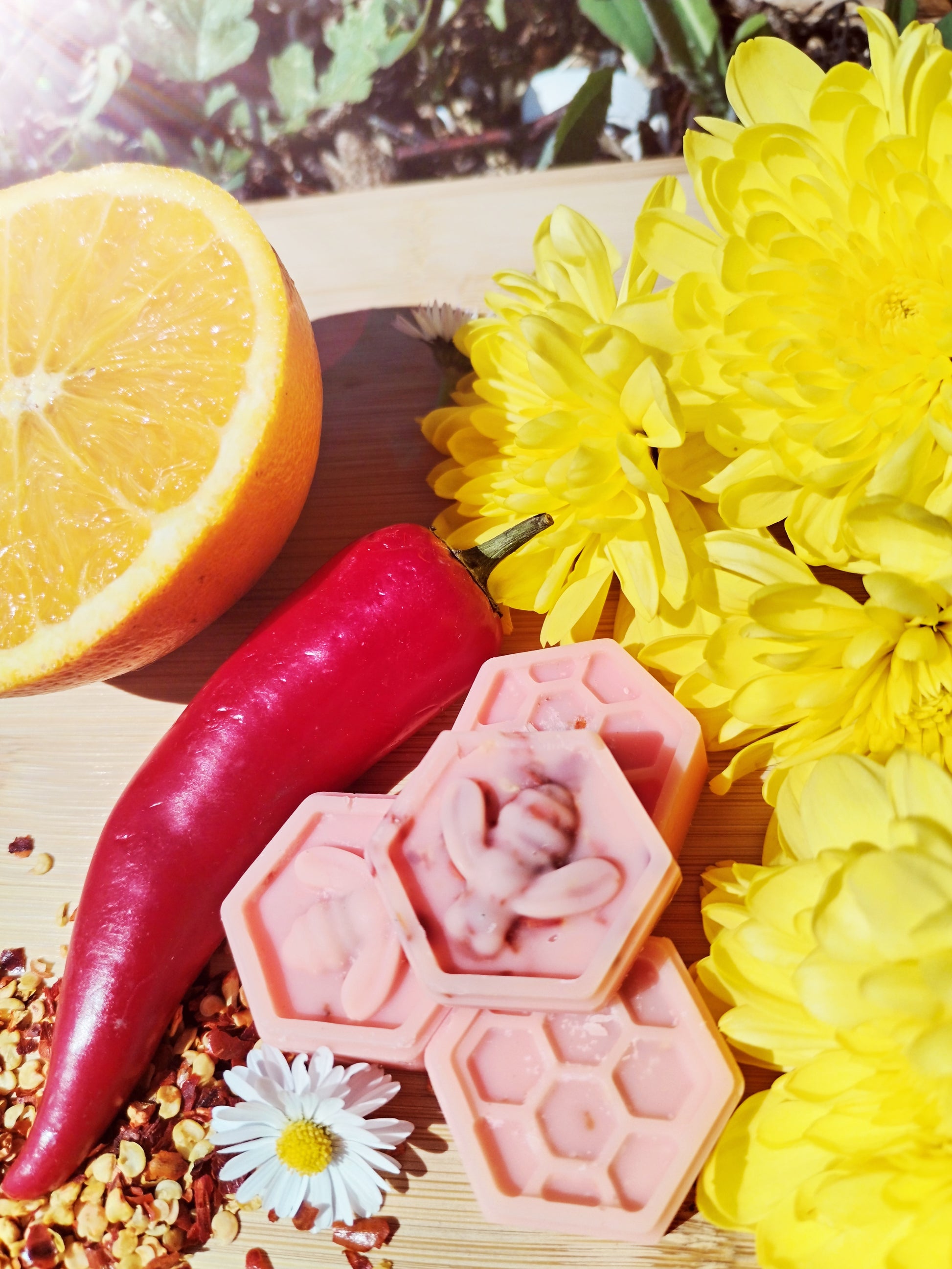 Handcrafted Honeycomb Wax Melts with Bee, Chilli Pepper, Orange, Daisy, and Yellow Flowers on Bamboo Chopping Board - A Symbol of Natural Delight and Mystical Ambiance