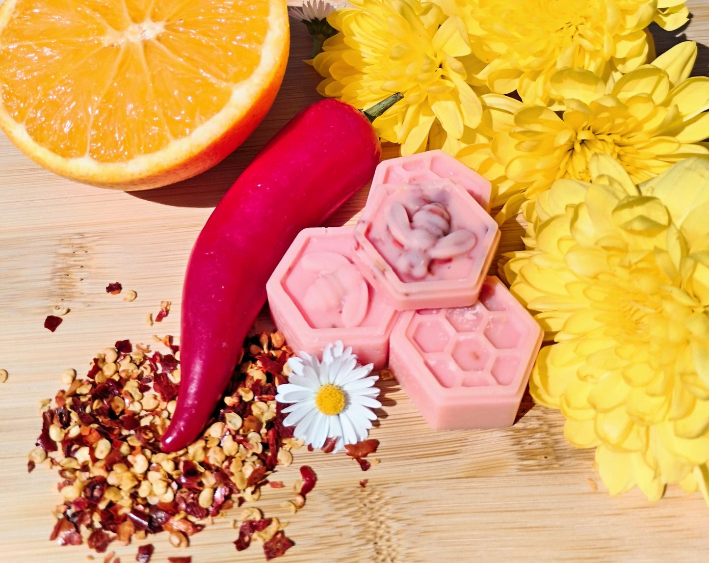 Handcrafted Honeycomb Wax Melts with Bee, Chilli Pepper, Orange, Daisy, and Yellow Flowers on Bamboo Chopping Board - A Symbol of Natural Delight and Mystical Ambiance