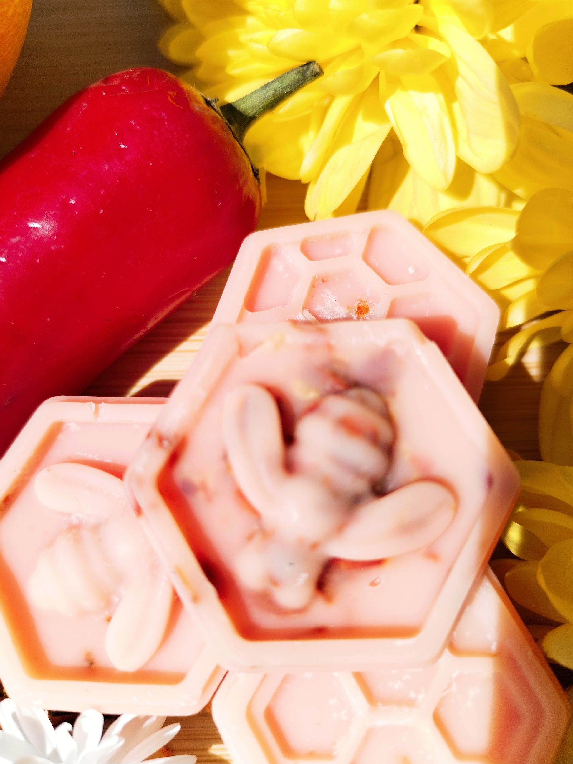 Handcrafted Honeycomb Wax Melts with Bee, Chilli Pepper, Orange, Daisy, and Yellow Flowers on Bamboo Chopping Board - A Symbol of Natural Delight and Mystical Ambiance