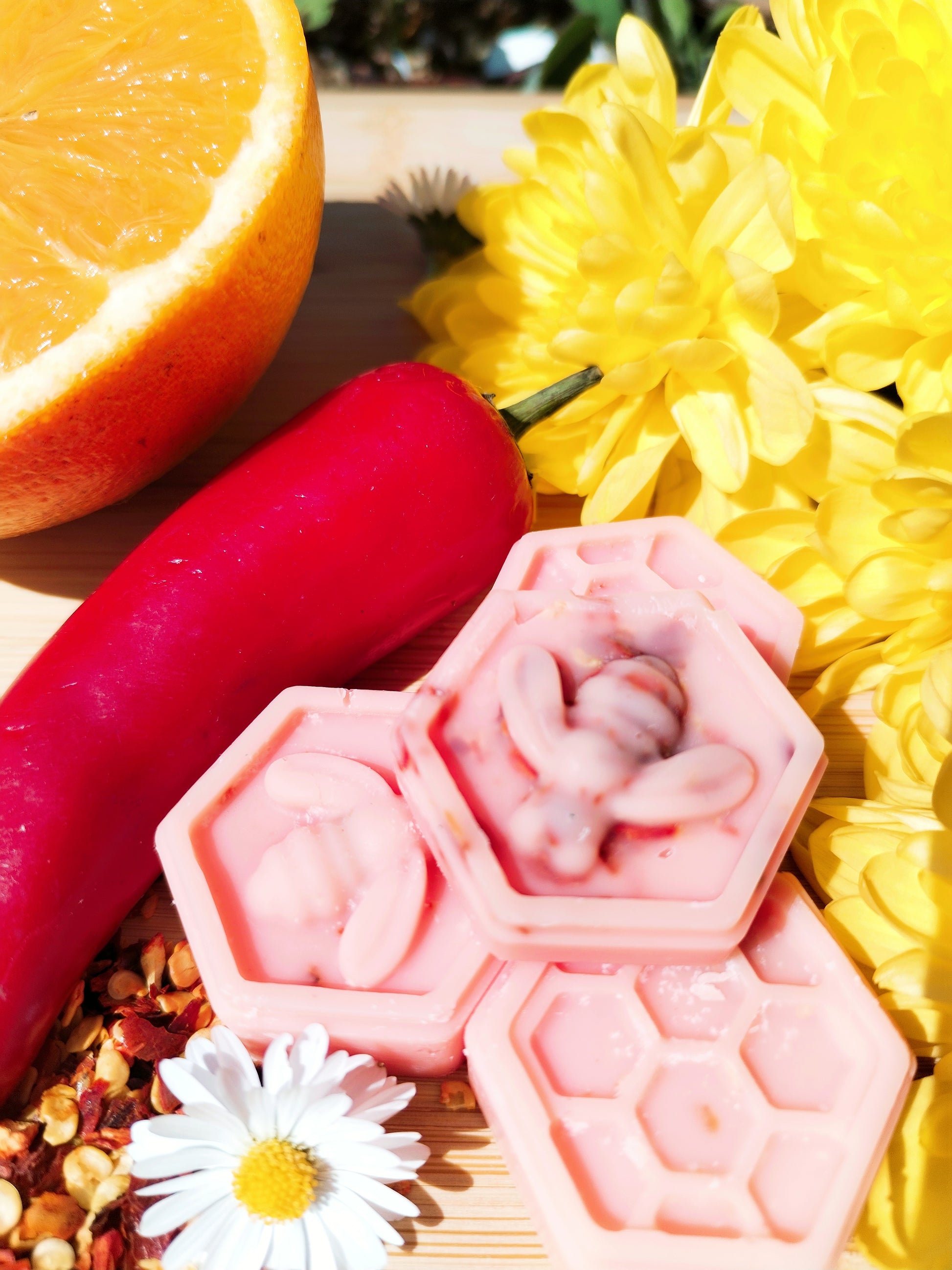 Handcrafted Honeycomb Wax Melts with Bee, Chilli Pepper, Orange, Daisy, and Yellow Flowers on Bamboo Chopping Board - A Symbol of Natural Delight and Mystical Ambiance