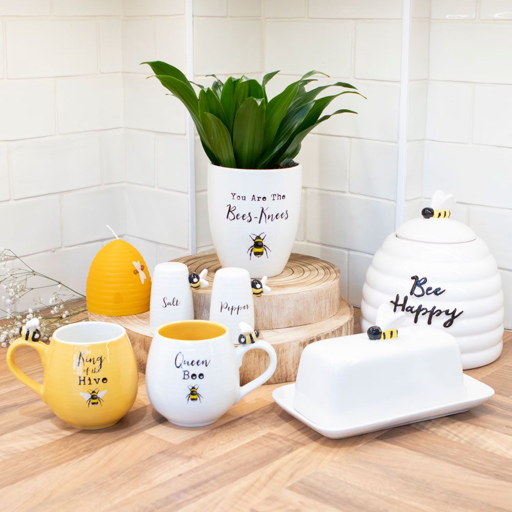 Bee-Themed Decor Display: 'You're the Bees Knees' plant pot, bee-inspired accents, rustic counter, subway tile wall.